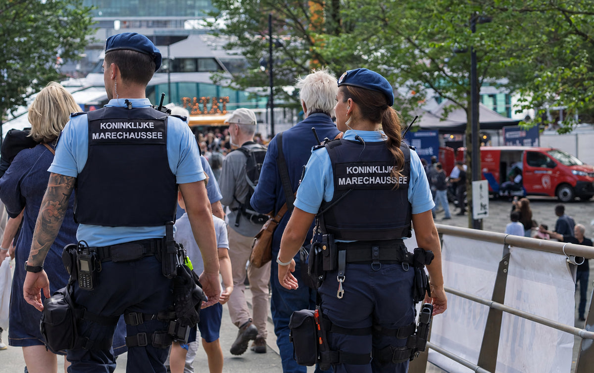Medewerkers van een overheidsdienst lopen door een druk stadsplein